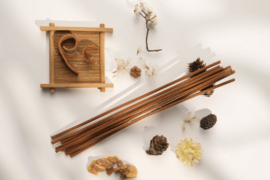 Flat lay of Chomolung Snow Tibetan incense sticks surrounded by dried herbs, pinecones, and resins on a white background, evoking a clean and refreshing alpine vibe.