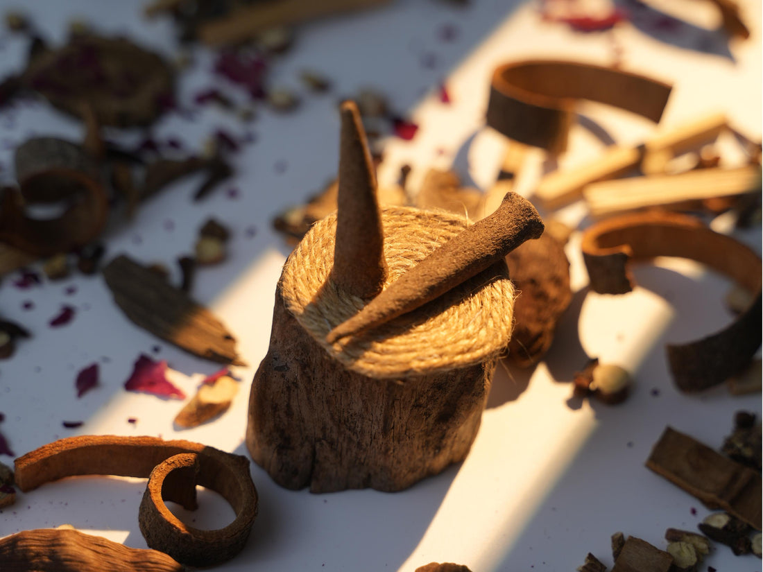 Handcrafted Sera Serene Tibetan incense cones on a rustic holder, surrounded by herbal ingredients in warm afternoon light.