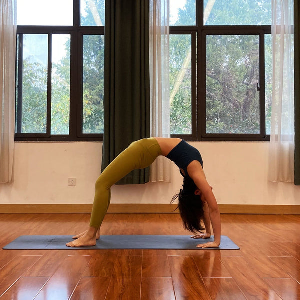 Co-founder of Lhasa Remedy TingTing practicing yoga in a serene studio with natural light and wooden floors, symbolizing mindfulness and intention behind the brand.