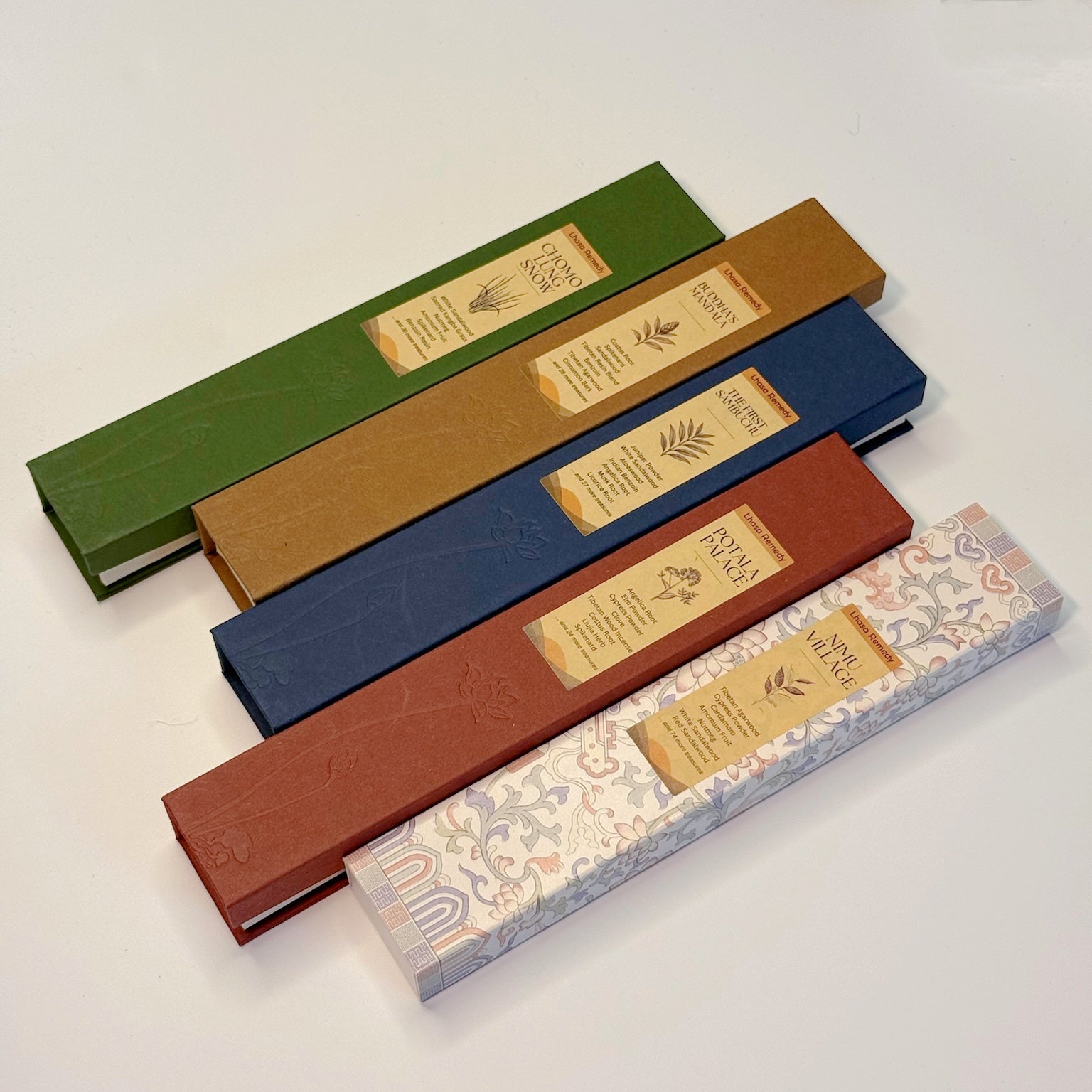 Five Lhasa Remedy Tibetan incense gift boxes—Nimu Village, Potala Palace, Sera Serene, Buddha’s Mandala, and Chomolung Snow—arranged in a colorful flatlay.