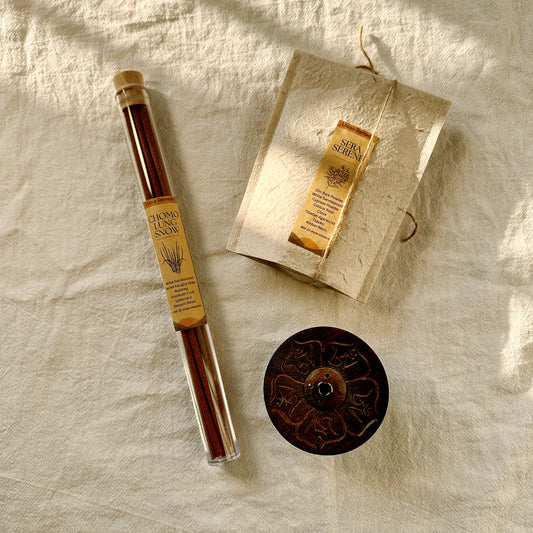 Wind Horse Purification Collection by Lhasa Remedy, featuring Chomolung Snow incense sticks, Sera Serene incense cones, and a mantra-engraved incense holder, displayed on natural fabric with soft golden light.